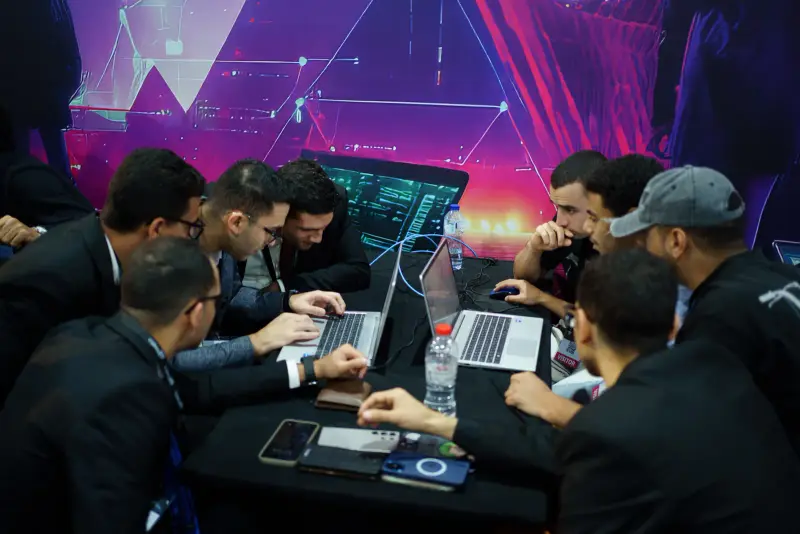 Team working together in front of a vivid magenta cyber backdrop, Connecta 2025