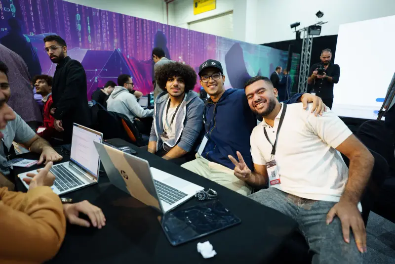 Cheerful team posing with peace signs at their competition table, Connecta 2025