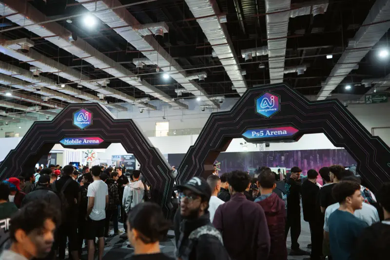 Crowd streaming through the neon gaming arena arches, Connecta 2025