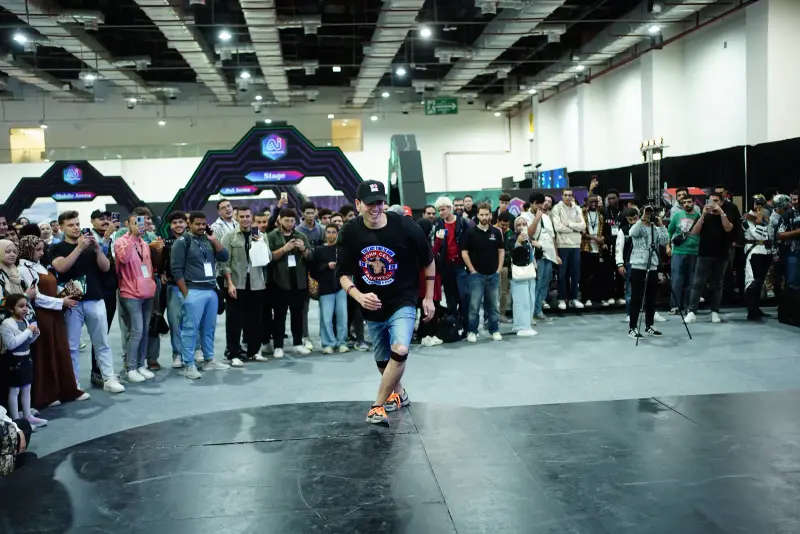 Dancer mid-move in the centre of a large crowd circle, Connecta 2025