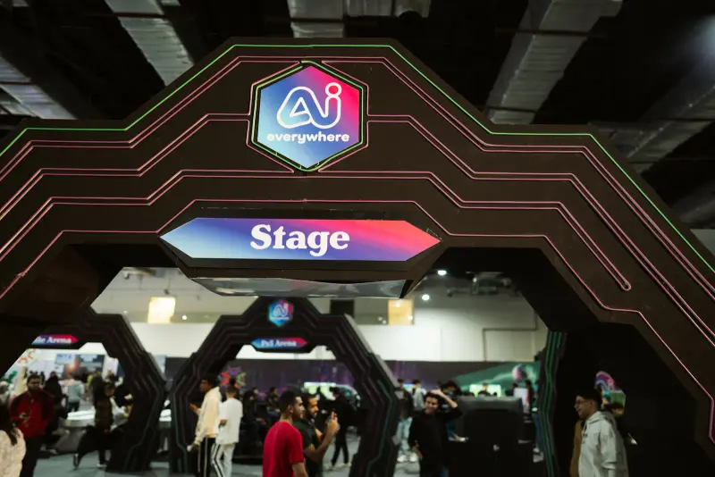 Neon "Stage" gate with visitors flowing through Hall 4, Connecta 2025