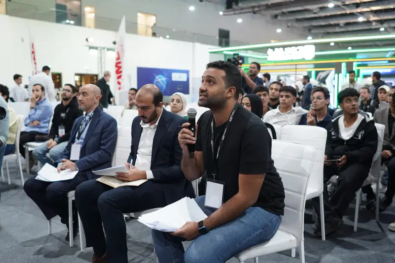 Attendee asking a question from a full audience during the pitches, Connecta 2025