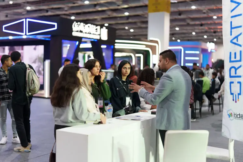 Visitors in conversation with an advisor at an innovation hub desk, Connecta 2025