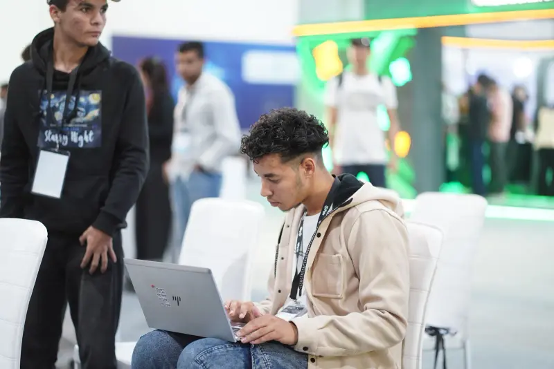 Young founder working on a laptop in the arena, Connecta 2025