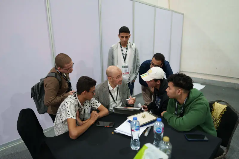 Mentoring session with a group of young innovators at a table, Connecta 2025