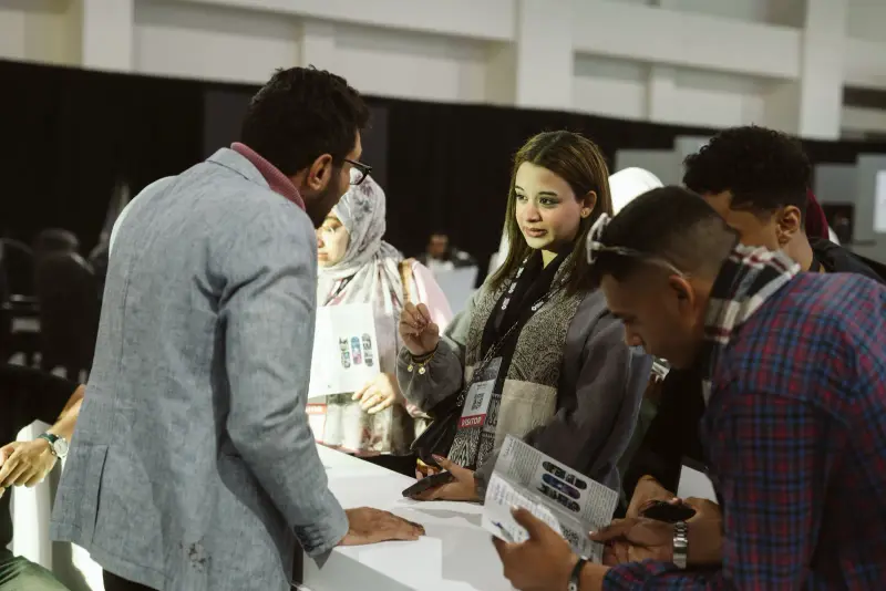 Young founders chatting with visitors at a startup desk, Connecta 2025