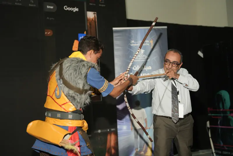 Cosplayer archer playfully duels a guest with a prop bow, Connecta 2025
