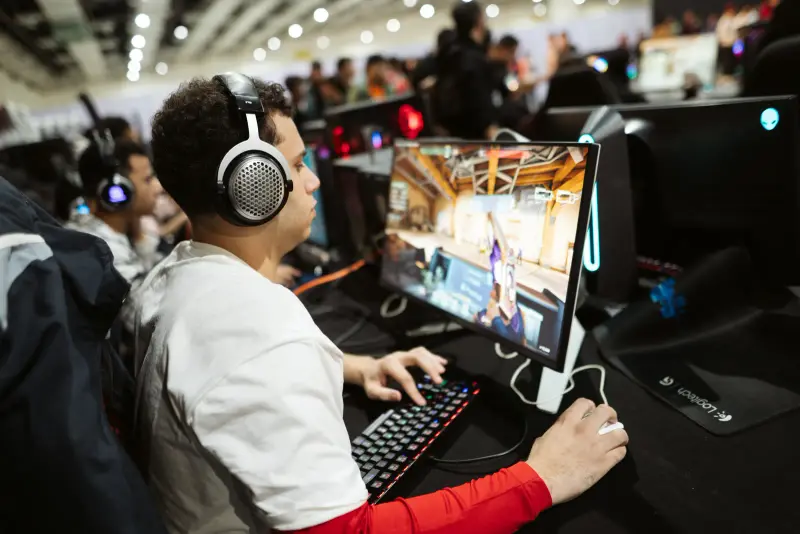 Gamer in headphones mid-match at a PC station in the Connecta Play arena, Connecta 2025