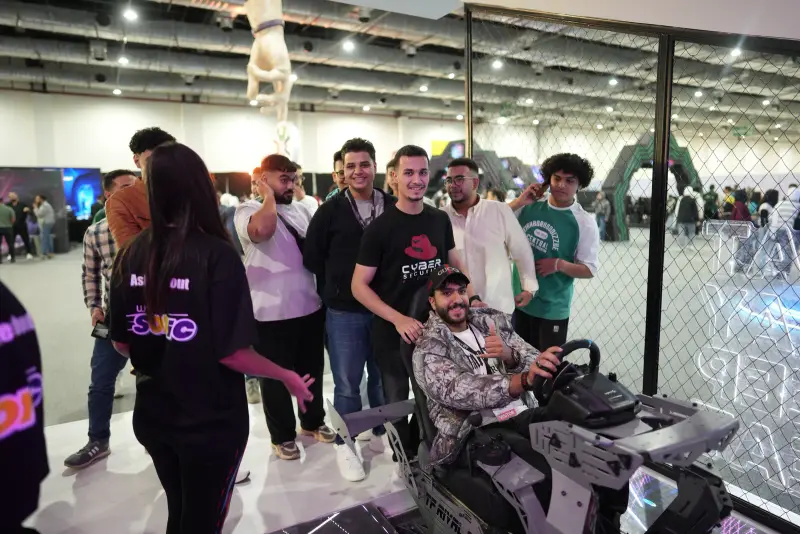 Friends cheering around a racing simulator driver, Connecta 2025